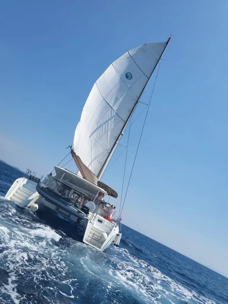 Der Katamaran Happiness unter Segeln auf dem offenen Meer